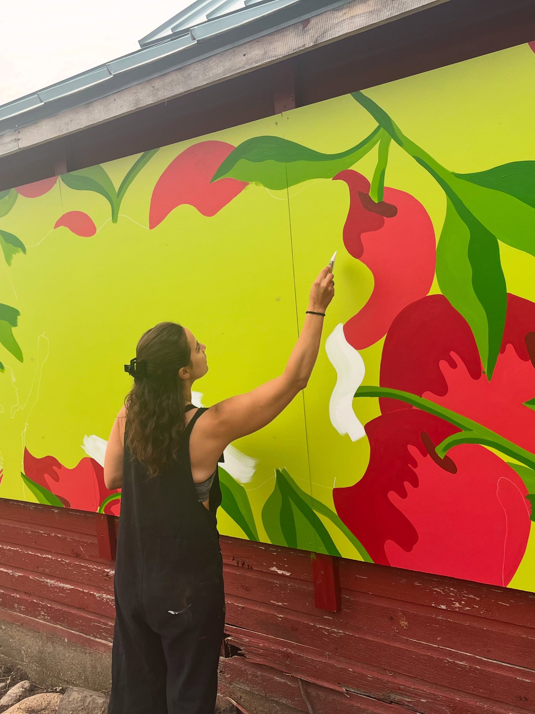 Crystalle Mercedes painting the apple pattern on the Macintosh Orchards barn