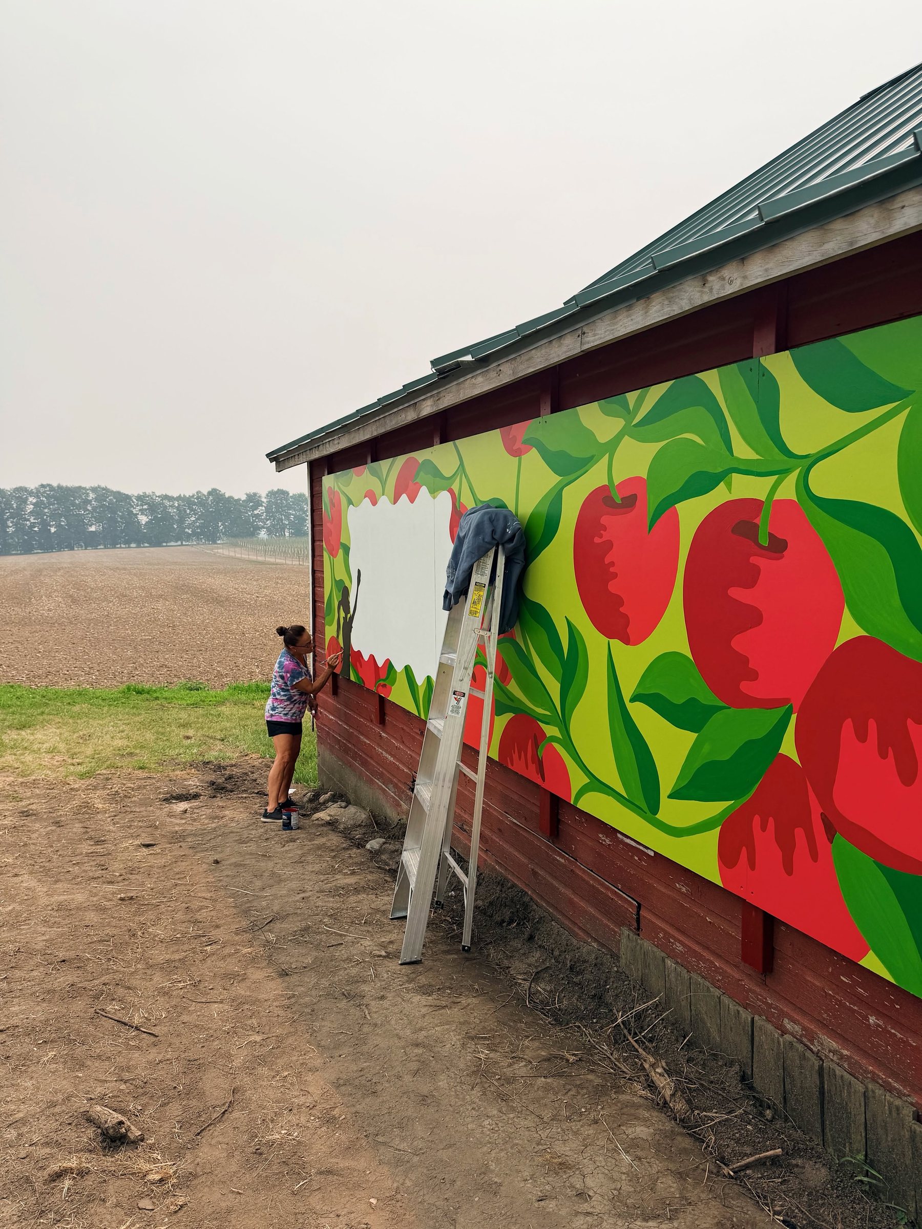 Finishing touches being added to the mural from a ladder